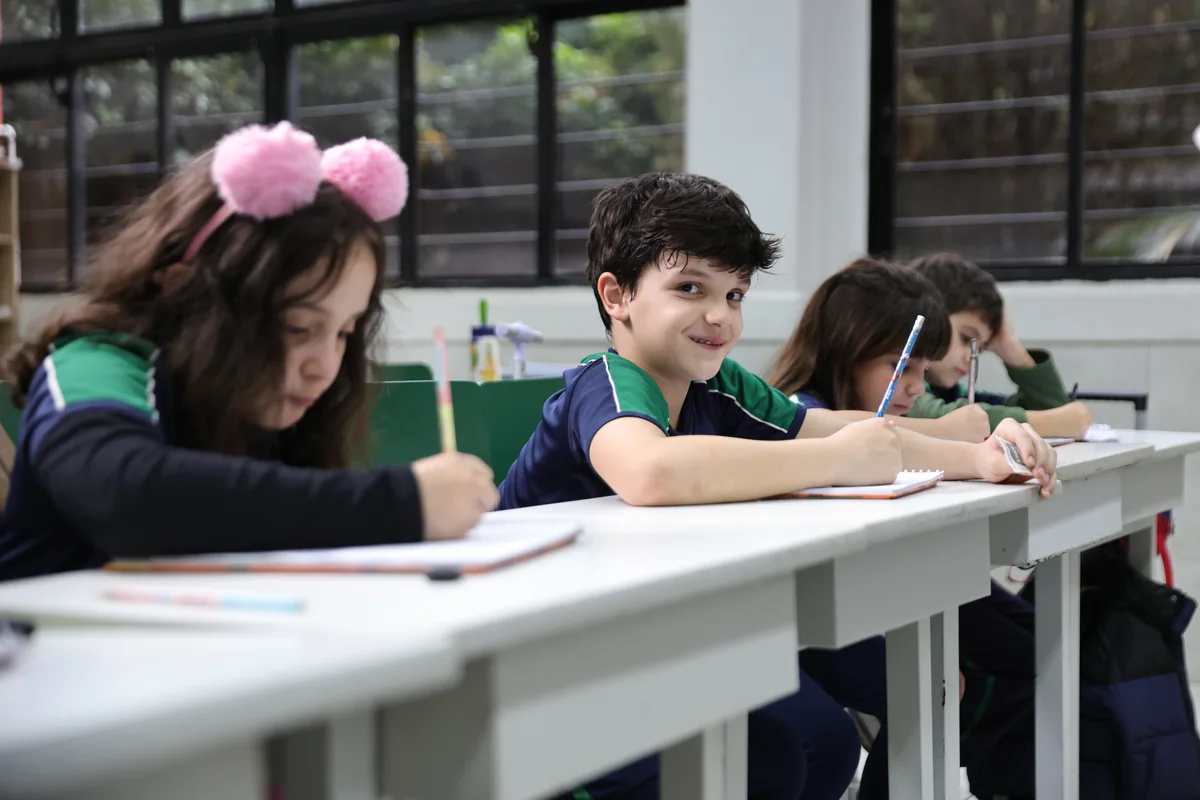 Alunos do Colégio Universitário escrevendo em sala de aula durante atividade do Ensino Fundamental