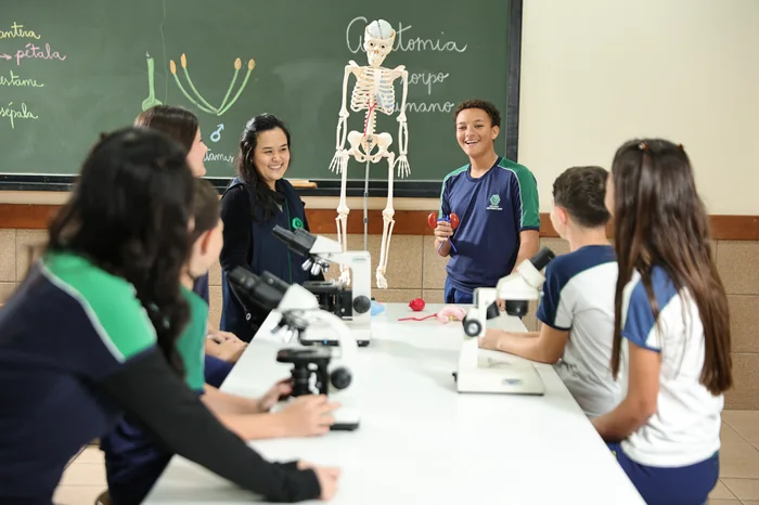 Alunos do Colégio Universitário em aula de ciências observando um esqueleto humano