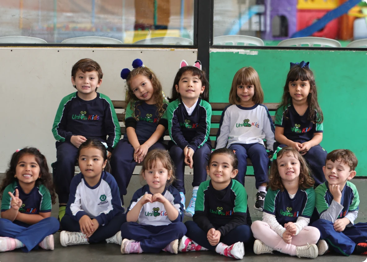 Grupo de alunos do Colégio Universitário sentados, sorrindo para a foto