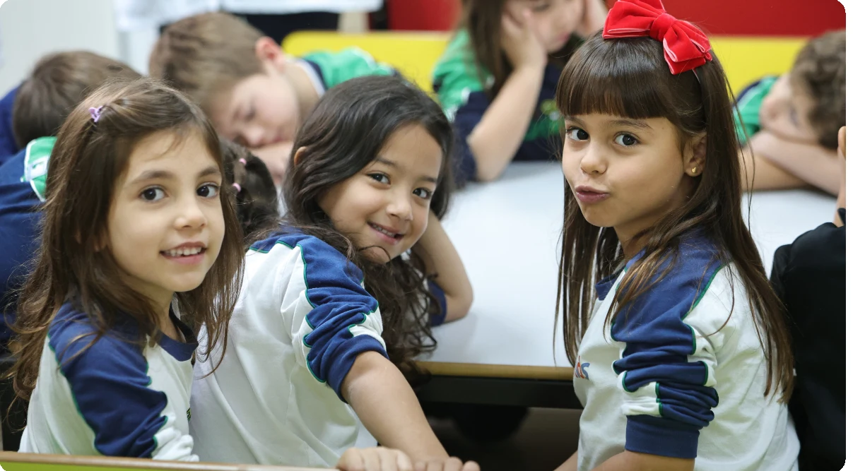 Alunas do Colégio Universitário sorrindo durante atividade em sala de aula